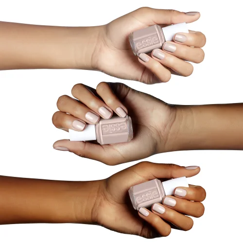 Three hands holding Essie nail polish bottles in a light nude shade called Topless And Barefoot, displaying manicured nails painted in the same color against a white background.